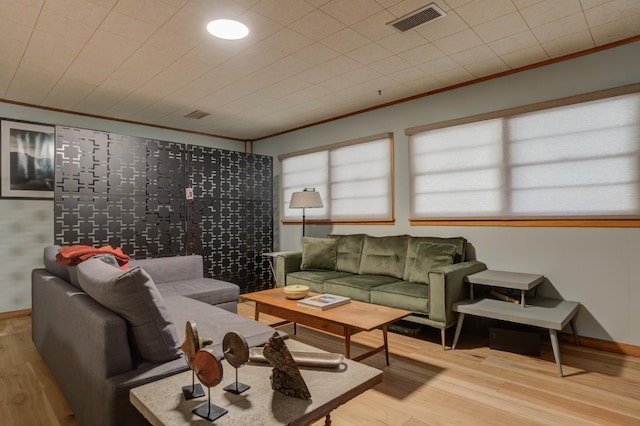 living room with crown molding and light wood-type flooring