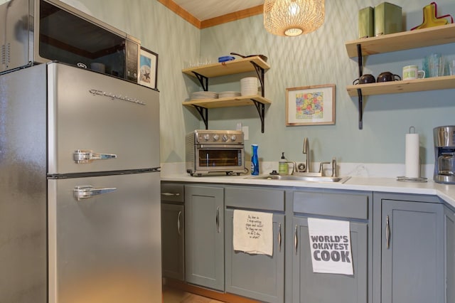 kitchen featuring gray cabinets, sink, and stainless steel refrigerator