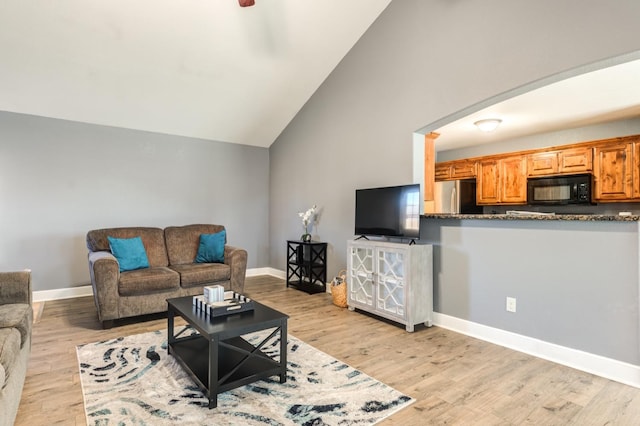 living room with vaulted ceiling and light hardwood / wood-style flooring