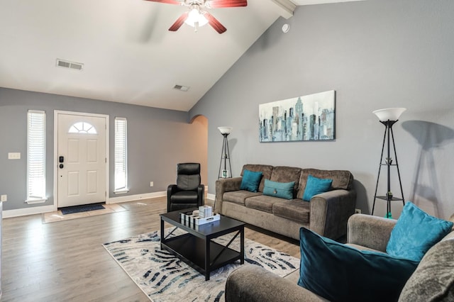 living room featuring hardwood / wood-style flooring, ceiling fan, beam ceiling, and high vaulted ceiling