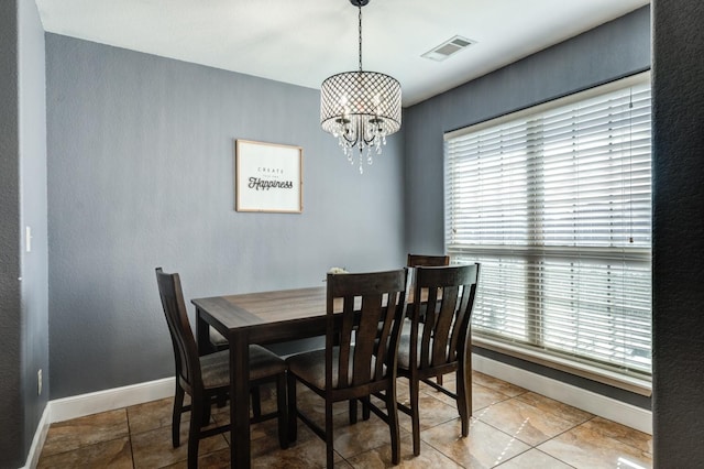 tiled dining room featuring a chandelier