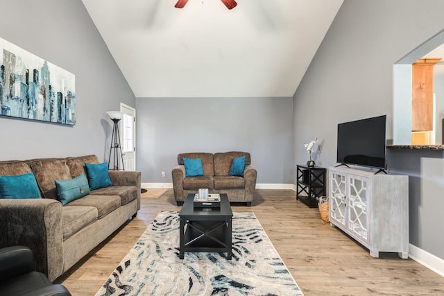 living room featuring ceiling fan, lofted ceiling, and light wood-type flooring