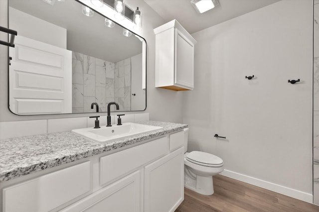 bathroom with vanity, hardwood / wood-style flooring, and toilet