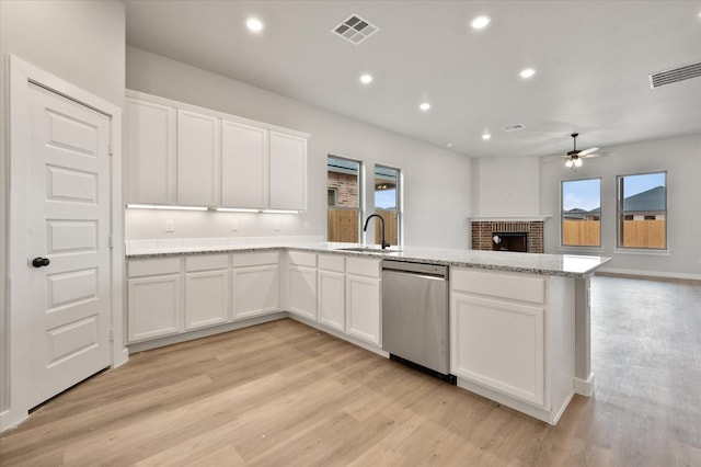 kitchen with white cabinetry, light stone countertops, stainless steel dishwasher, and light hardwood / wood-style floors