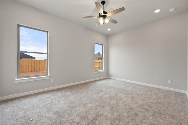 carpeted spare room with ceiling fan