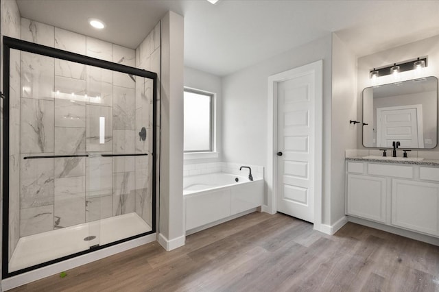 bathroom with vanity, hardwood / wood-style flooring, and shower with separate bathtub