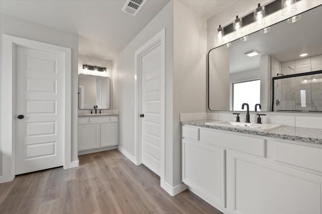 bathroom with a shower with door, wood-type flooring, and vanity