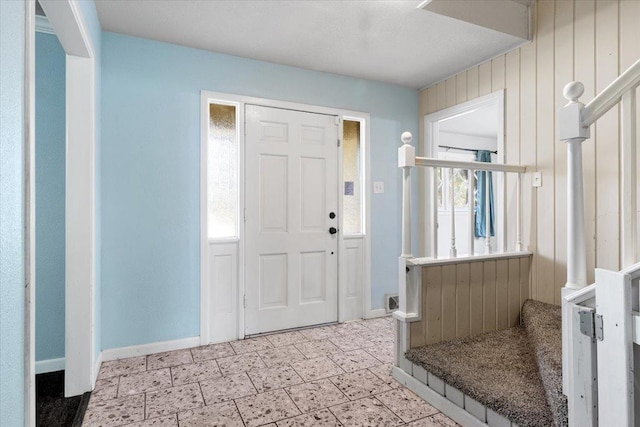 entrance foyer featuring wood walls