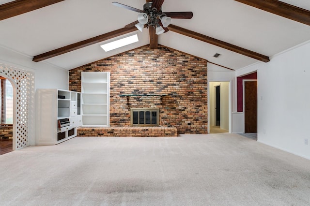 unfurnished living room with ceiling fan, light colored carpet, vaulted ceiling with skylight, and brick wall