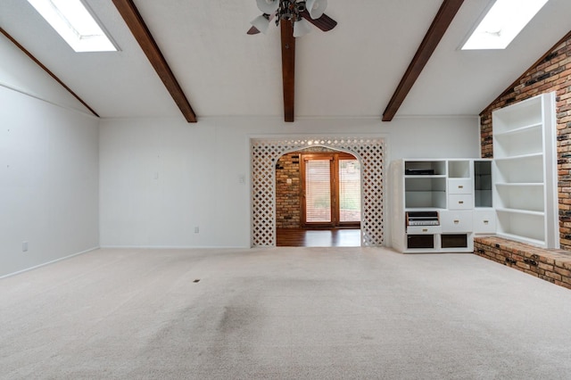 unfurnished living room featuring ceiling fan, lofted ceiling with skylight, and carpet floors