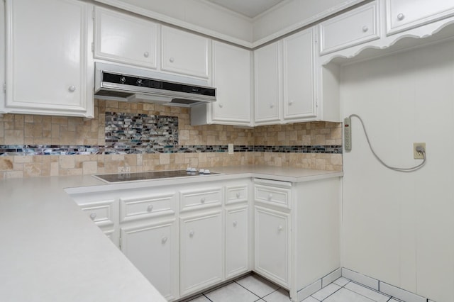 kitchen with white cabinetry, black electric stovetop, decorative backsplash, and light tile patterned flooring