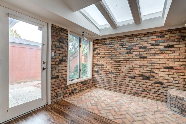 unfurnished sunroom featuring vaulted ceiling with skylight