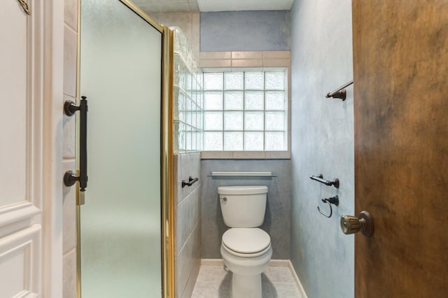 bathroom with toilet, tile patterned flooring, and a shower with door