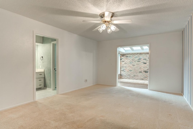 carpeted empty room featuring ceiling fan and a textured ceiling