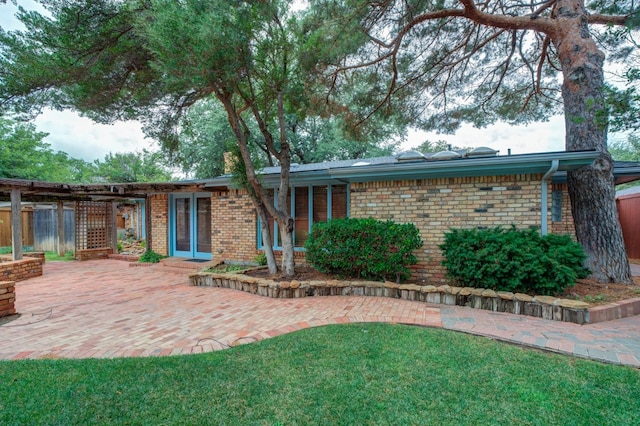 ranch-style home with a front yard and a patio