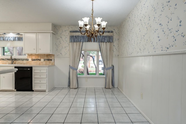 kitchen featuring sink, a chandelier, light tile patterned floors, dishwasher, and white cabinets