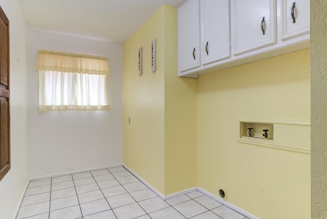 washroom with cabinets, washer hookup, and light tile patterned floors