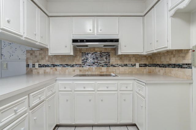 kitchen featuring black electric stovetop, white cabinets, and backsplash