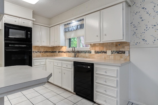 kitchen with sink, white cabinets, light tile patterned floors, black appliances, and a textured ceiling