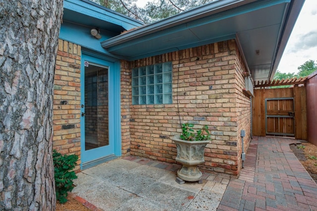 view of exterior entry with a patio