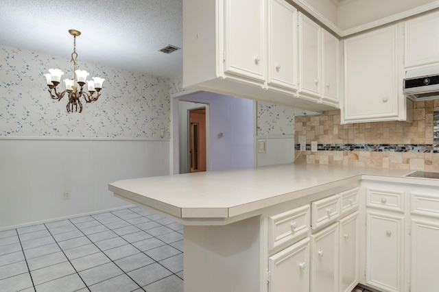 kitchen featuring pendant lighting, light tile patterned floors, white cabinetry, and kitchen peninsula