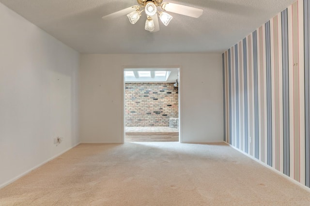 carpeted empty room featuring ceiling fan and a textured ceiling