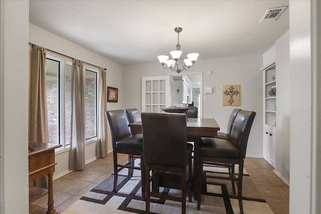 tiled dining space with a chandelier and built in features