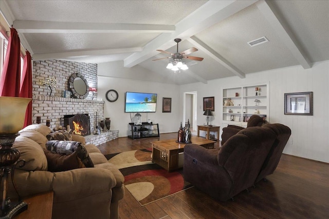 living room with built in features, vaulted ceiling with beams, dark hardwood / wood-style floors, a fireplace, and a textured ceiling