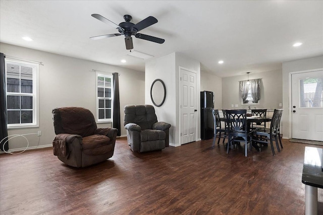 living room featuring ceiling fan and dark hardwood / wood-style flooring