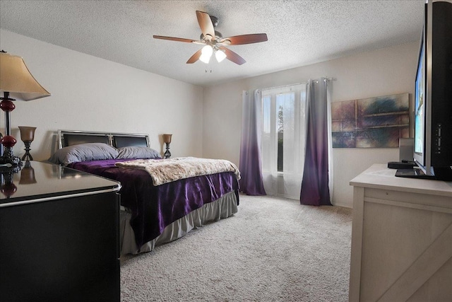 carpeted bedroom featuring ceiling fan and a textured ceiling