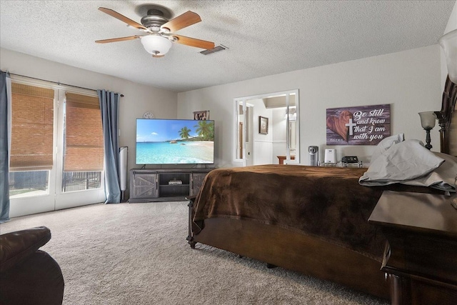 carpeted bedroom featuring access to exterior, a textured ceiling, ceiling fan, and ensuite bath