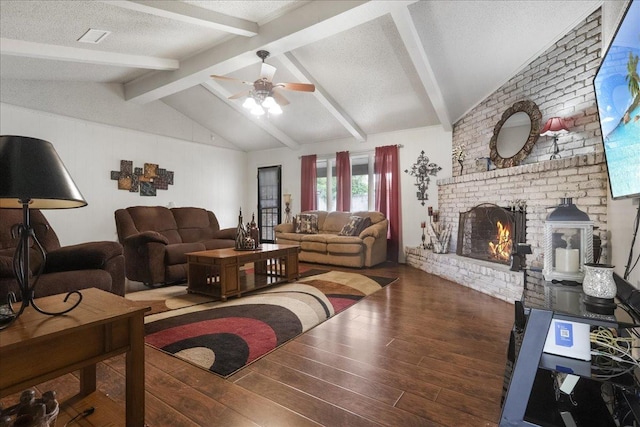 living room featuring vaulted ceiling with beams, a brick fireplace, a textured ceiling, dark hardwood / wood-style flooring, and ceiling fan