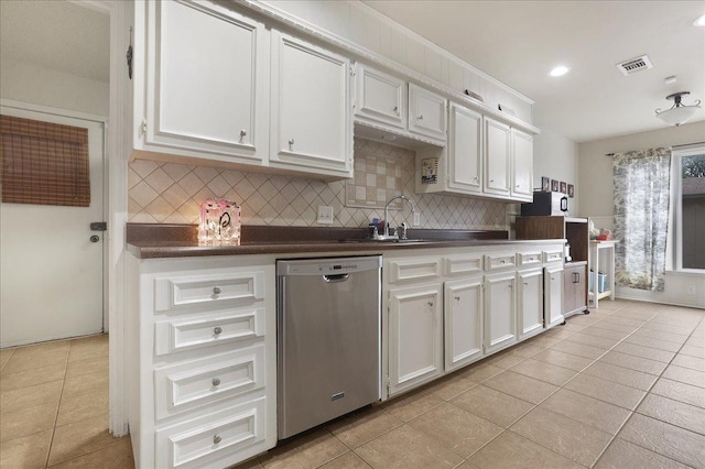 kitchen featuring tasteful backsplash, white cabinets, light tile patterned floors, and dishwasher