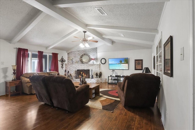 living room with dark wood-type flooring, a fireplace, lofted ceiling with beams, and a textured ceiling