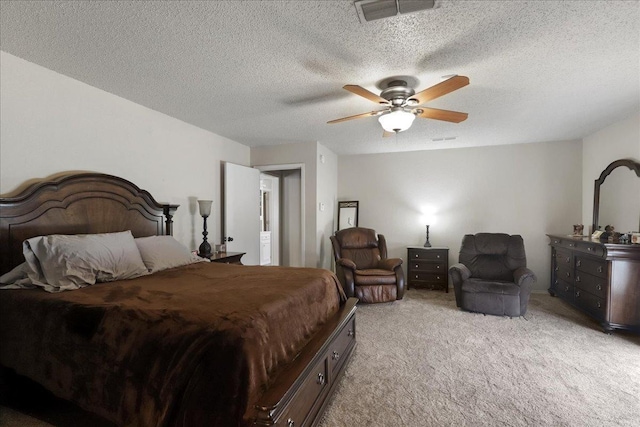 bedroom with a textured ceiling, light colored carpet, and ceiling fan