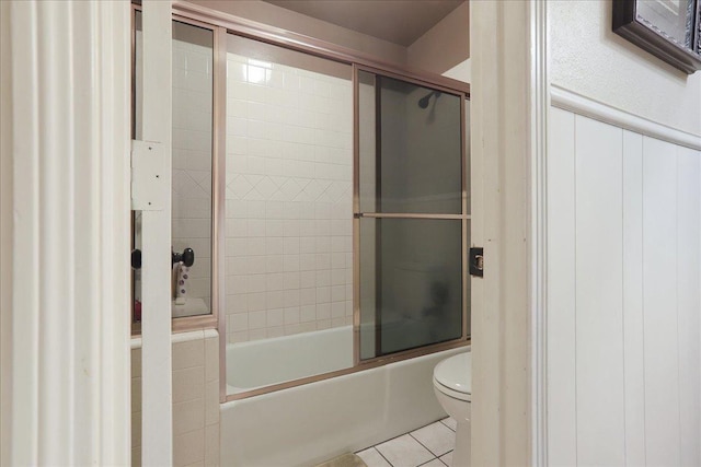 bathroom featuring tile patterned floors, shower / bath combination with glass door, and toilet