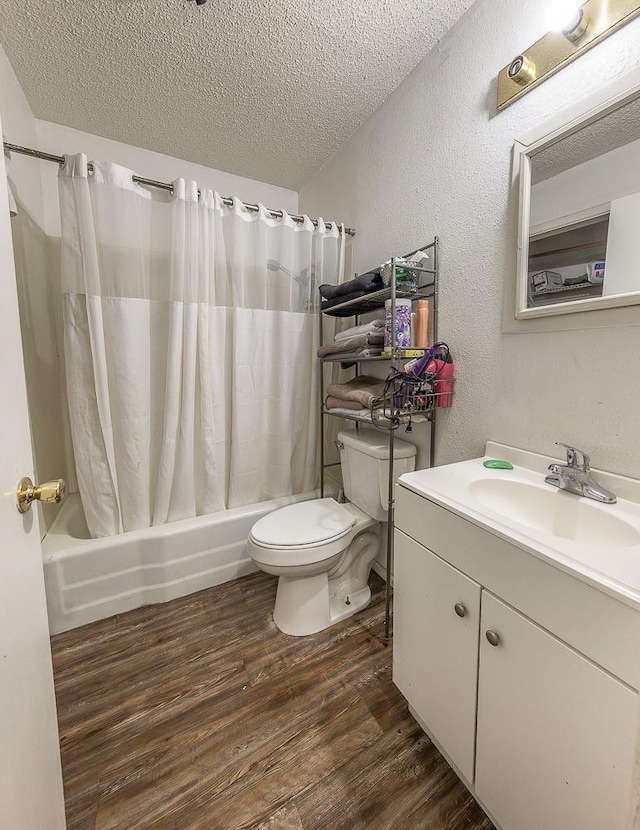 full bathroom featuring toilet, wood-type flooring, a textured ceiling, vanity, and shower / bath combo