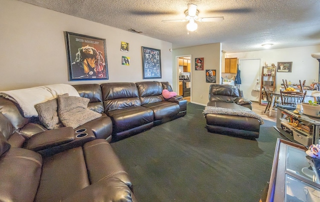 living room with ceiling fan and a textured ceiling