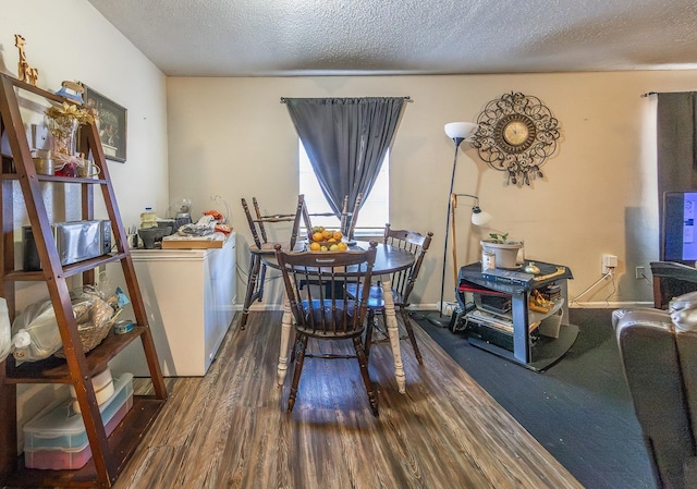 dining area featuring wood-type flooring and a textured ceiling