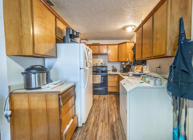 kitchen with black electric range oven, dark wood-type flooring, white refrigerator, a textured ceiling, and washer / dryer