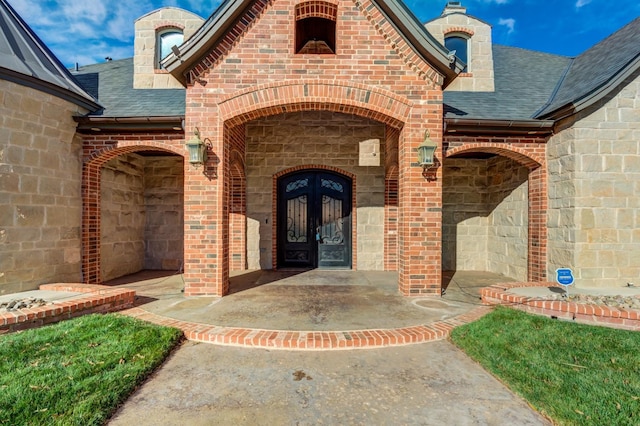 10704 Orlando Ave, Lubbock, TX 79423 - view of exterior entry featuring a shingled roof, brick siding, and stone siding