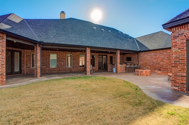 10704 Orlando Ave, Lubbock, TX 79423 - rear view of house featuring a yard, a chimney, french doors, brick siding, and a patio area