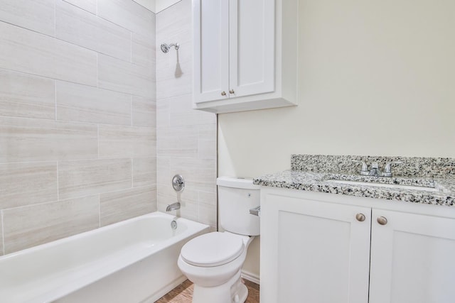 full bathroom featuring tiled shower / bath combo, vanity, and toilet