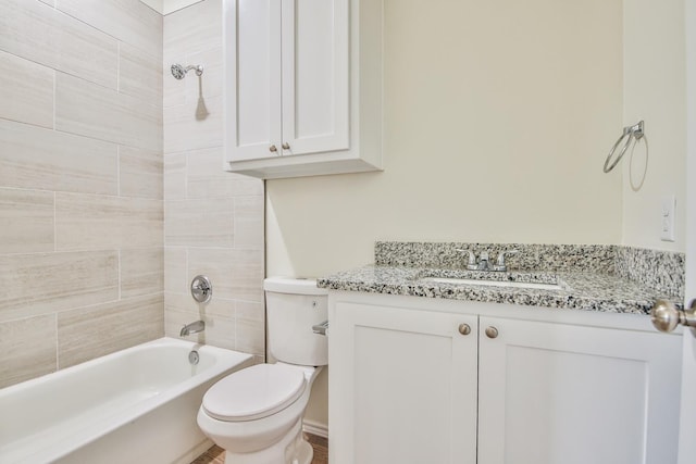 full bathroom with tiled shower / bath, vanity, and toilet