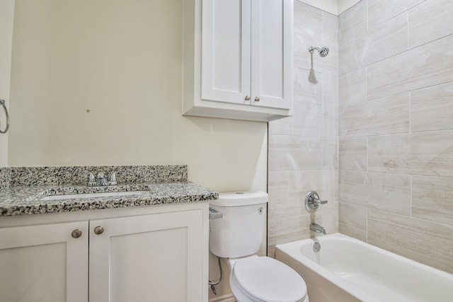 full bathroom featuring vanity, tiled shower / bath, and toilet