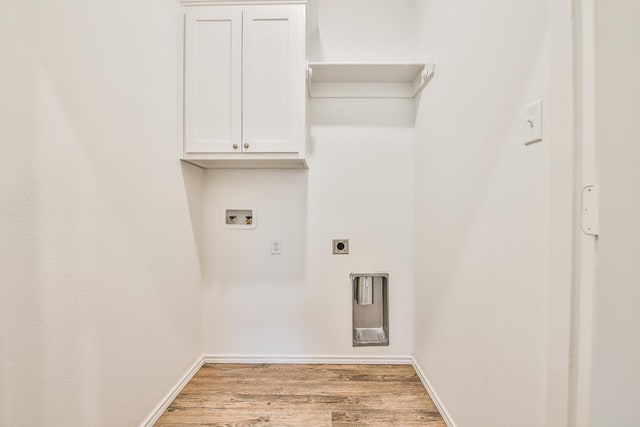 laundry room featuring electric dryer hookup, hookup for a washing machine, light hardwood / wood-style floors, and cabinets