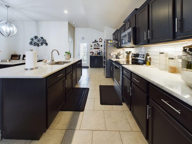 kitchen featuring appliances with stainless steel finishes, pendant lighting, sink, a kitchen island with sink, and light tile patterned floors