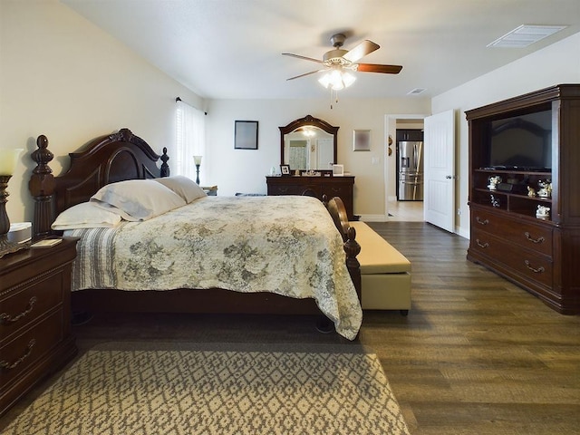 bedroom featuring stainless steel fridge, dark hardwood / wood-style floors, and ceiling fan