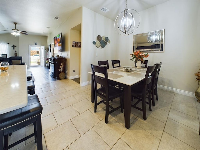 dining space featuring light tile patterned flooring and ceiling fan with notable chandelier