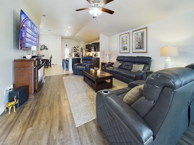 living room featuring vaulted ceiling, hardwood / wood-style floors, and ceiling fan